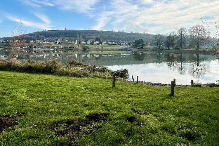 View of the countryside with a lake and trees in Etupes, France