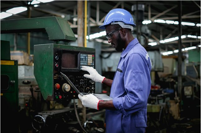 Person working on machinery in an automotive manufacturing facility