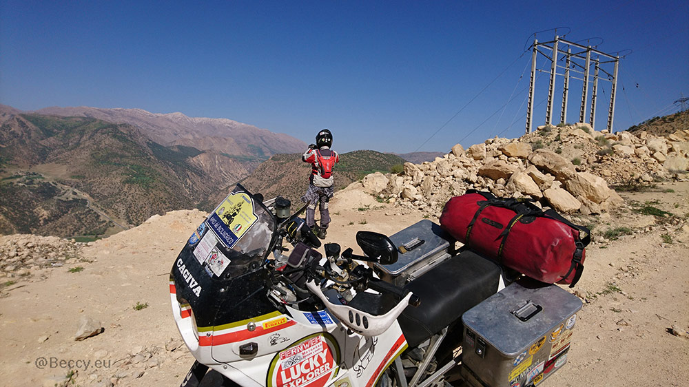 Rebecca Kleis standing on a mountain top looking out at a mountain range