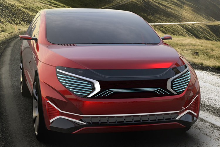 Red vehicle driving along a road lined with grass covered mountains