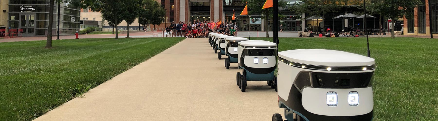 Autonomous delivery robots lined up on a walkway