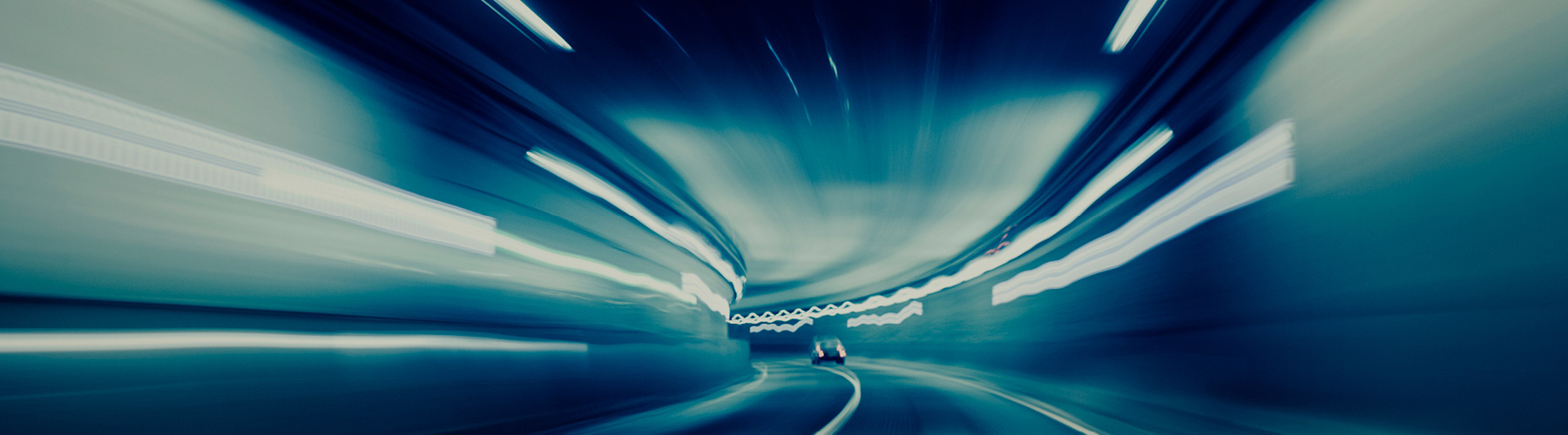 Picture of car driving through a lit tunnel