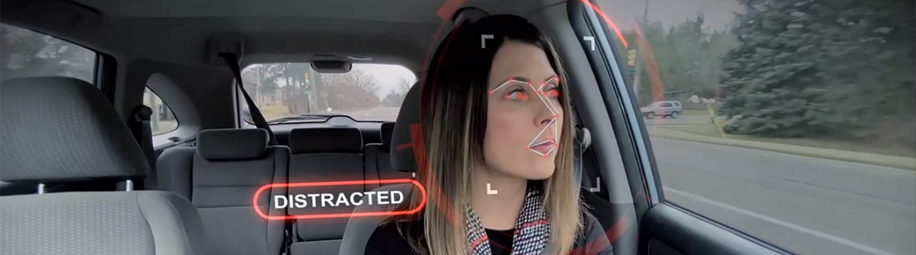 Person driving and the driver monitoring system analyzing driver distractions