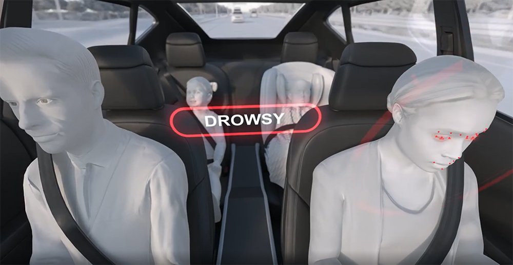 Full vehicle cabin view showing driver and occupant monitoring system detecting drowsy driver state and tracking passengers for advanced interior sensing.