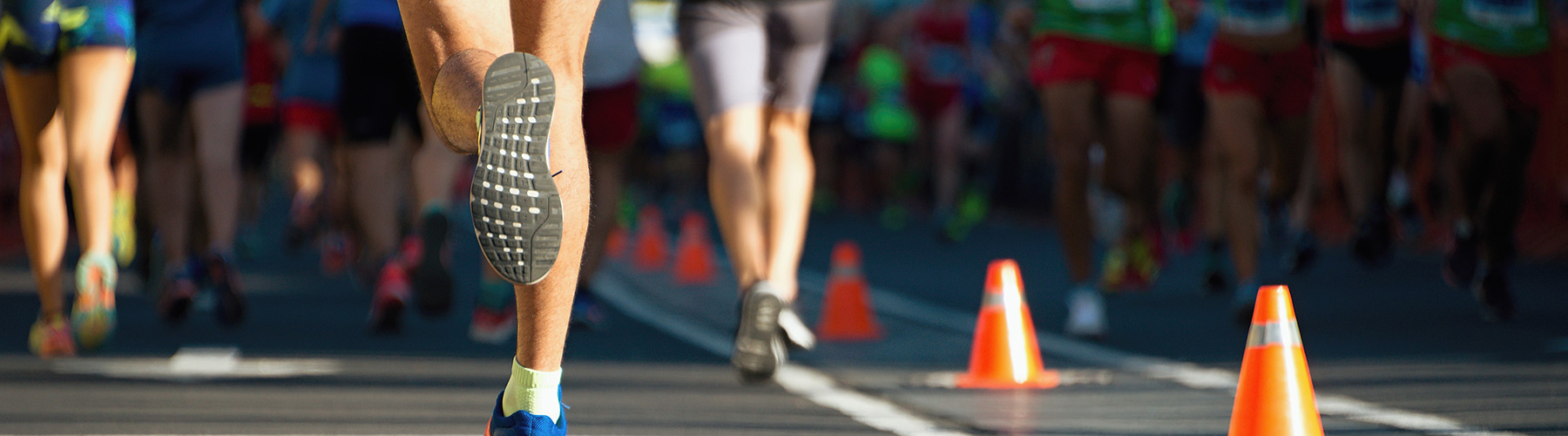 People's feet running a race with pilons lining the route